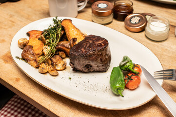 Saftiges Steak auf Teller mit Gemüse, Pilzen, Tomaten und Pepperonis auf Teller