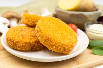 Potato cutlets with mushrooms on a white plate.