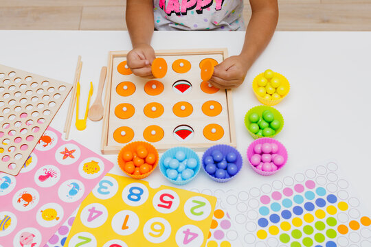 A child playing a children's educational game for the development of memory. It is necessary to find two of the same pictures. The concept of kids leisure and preschool education.