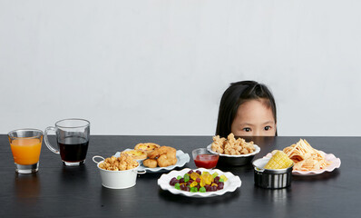 Asian little girl eating and playing indoors by herself