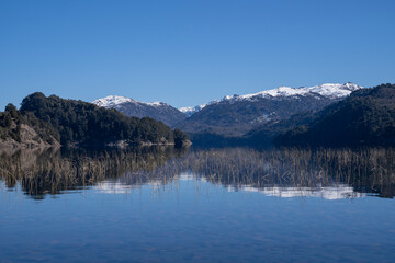 Beauty in nature. View of volcano Batea Mahuida, Andes mountains, forest and Alumine lake in Villa Pehuenia, Patagonia Argentina. Beautiful landscape and blue sky reflection in the glacier water.