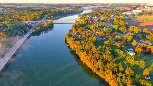 Steaming Autumn river at sunrise in small town USA, the Fox River in Wrightstown, Wisconsin, aerial view.