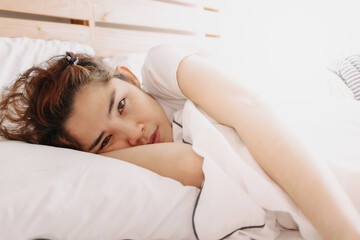 Obraz premium Happy asian woman just wake up on her bed in warm summer morning.