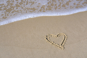 heart on the beach on the background of a light wave