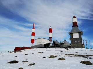 Antenna lighthouse shape construction at the top of the snowy mountain in Madrid Navacerrada Bola...