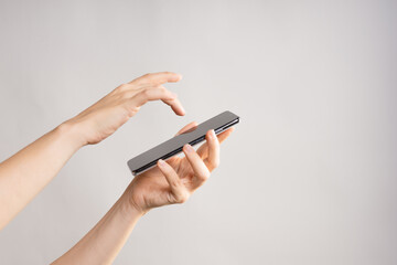 Use mobile apps, scroll. Smartphone, the female hand uses the touchpad, Layout for design, mockup. light grey background