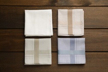 Different handkerchiefs folded on wooden table, flat lay