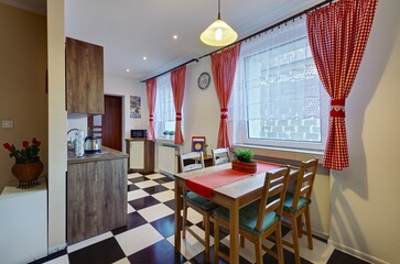 Stylowy salon z kuchnią z czerwonymi zasłonami - obrazy, fototapety, plakaty