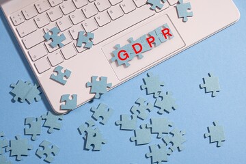 The pieces of the puzzle are collected in the word GDPR, a provision of the EU law on data protection and privacy in the European Union. Mosaic on the computer keyboard, blue background