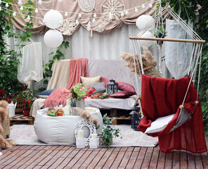 gazebo interior in folk style with pillows and coffee