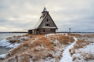 Snowy winter landscape with authentic cinematic house on the shore in the Russian village Rabocheostrovsk