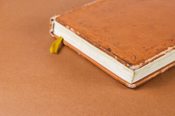 Close-up of a worn old notebook. A diary or planner with notes in a brown leather binder. Selective focus.