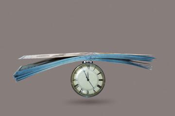 the hours and money isolated on a gray background,concept, do not waste time for which it is possible to earn money as loss of time is equivalent 