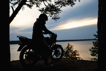 Plakat silhouette of a girl on a motorcycle at sunset