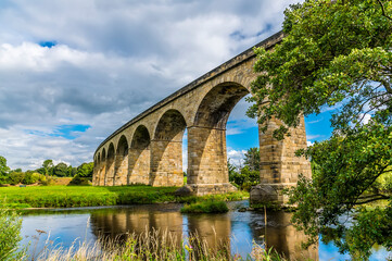 Fototapeta na wymiar The Arthington Viaduct crosses the River Wharfe in Yorkshire, UK in summertime