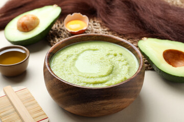 Homemade hair mask, ingredients and comb on beige background