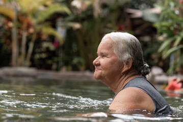 Mujer adulto mayor disfrutando de unas deliciosas aguas termales  del Volcán Arenal de Costa Rica