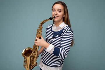 Photo shot of beautiful happy smiling brunette little girl wearing striped longsleeve standing...