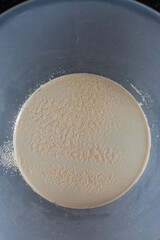 Instant dry yeast sprinkled on warm water, dry yeast granules on water