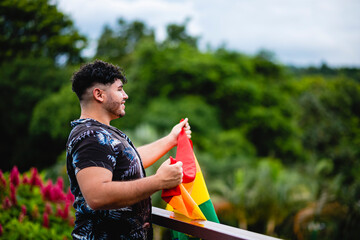 Joven homosexual con su bandera de la diversidad muy orgulloso en exterior