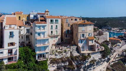 Fototapeta na wymiar Aerial view of old houses built on the edge of the cliffs of Bonifacio overlooking the Mediterranean Sea in the south of the island of Corsica, France