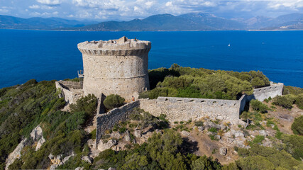 Fototapeta na wymiar Aerial view of the ruins of the Genoese tower on Campomoro Cape in the South of Corsica, France - Torra di Campumoru surrounded by walls on a lookout above the Mediterranean Sea