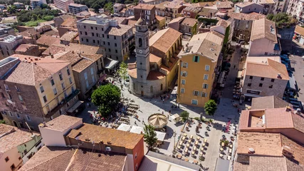 Fotobehang Aerial view of the Place de la République in the old city center of Porto-Vecchio in the South of Corsica, France - Church of Saint John the Baptist in a citadel built by the Genoese © Alexandre ROSA
