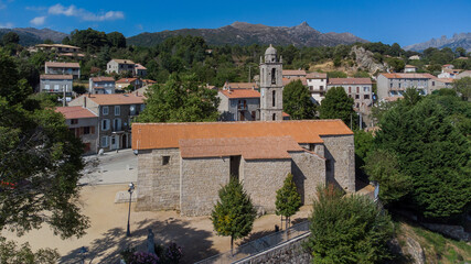 Fototapeta na wymiar Aerial view of the mountainous village of Quenza in the Alta Rocca region of the South of Corsica, France - St. George's Church in front of the famous Bavella Peaks