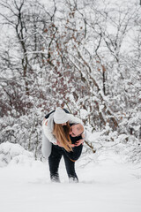 Couple playing with snow in the forest