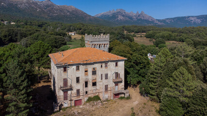 Fototapeta na wymiar Aerial view of the mountainous village of Quenza in the Alta Rocca region of the South of Corsica, France - Abandoned castle in front of the famous Bavella Peaks