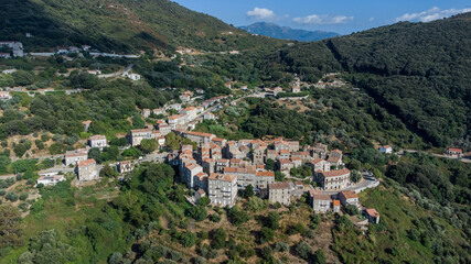 Fototapeta na wymiar Aerial view of the village of Sainte Lucie de Tallano in the mountains of Southern Corsica, France - Round shaped medieval village with old houses surrounded by pine forests