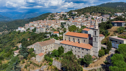 Fototapeta na wymiar Aerial view of the Convent of Saints Cosimo and Damian of Sartène in the mountains of the South of Corsica, France - Regional capital, Sartène is mostly made of granite buildings