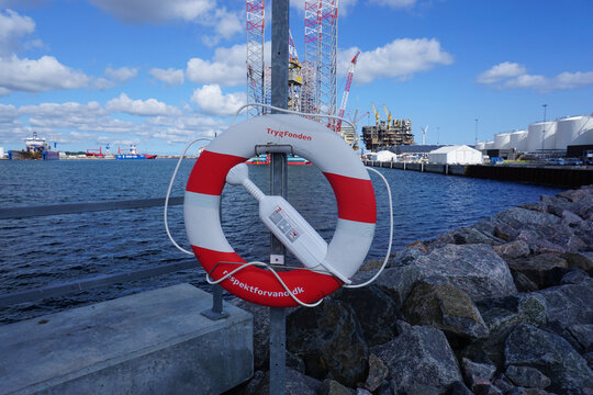 Ein Rettungsring im Vordergrund und der Hafen von Frederikshavn im Hintergrund 