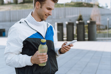 Smiling sportsman using online app in modern smartphone