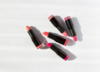 Fototapeta na wymiar colored bright lipstick on a white background with shadows