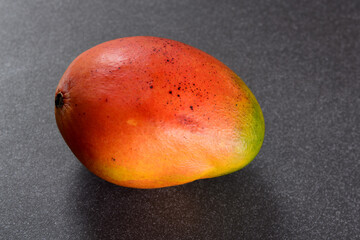 a ripe mango with a mixture of red and orange tones
