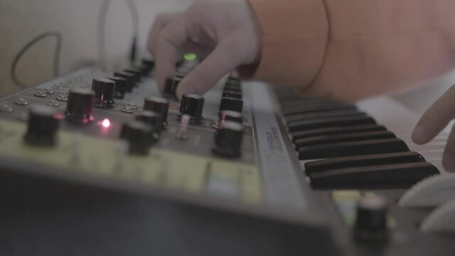hands playing synthesizer, a flat video of hands playing synthesizer to compose electronic music