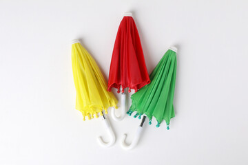 Small color umbrellas on white background, top view