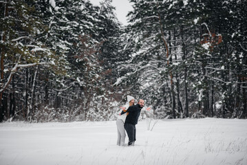 Couple playing with snow in the forest