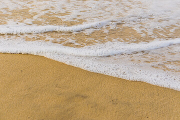wave, sea foam and beach sand