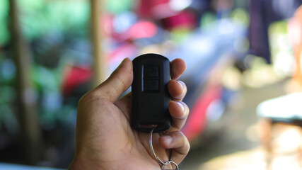Motorcycle key on hand with blurred motorcycle background illustrating a security