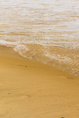 wave, sea foam and beach sand
