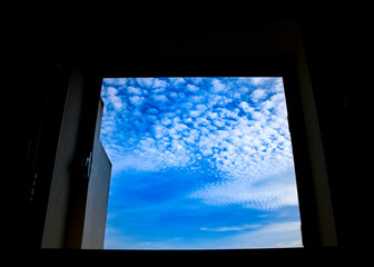 Sky with altocumulus floccus clouds through the window - obrazy, fototapety, plakaty