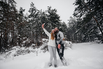 Couple playing with snow in the forest