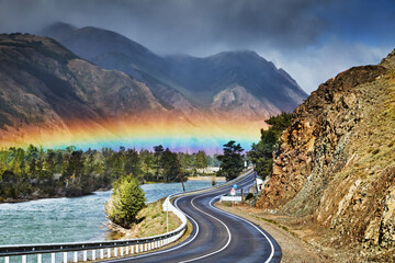 Mountain landscape, rainbow over road