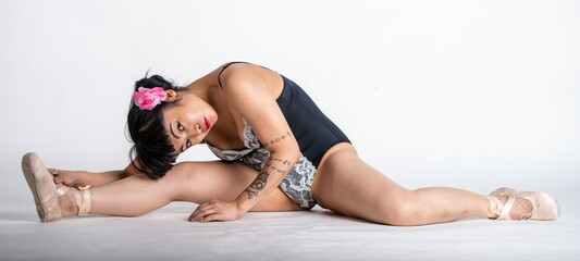 young Asian model in ballet slippers and an outfit that she designed and sewed doing the splits against a white background. © Robert McAlpine