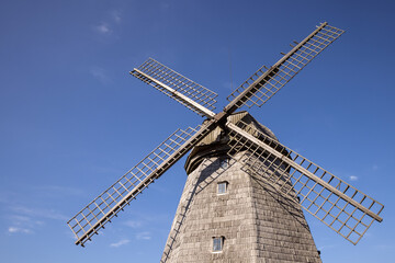 Old wooden wind mill in Lazdininkai village, Darbėnai, Lithuania on a sunny day. Old traditional Dutch mill. 
