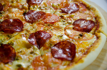 pizza with salami and cheese close up in a contrasting light