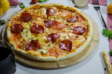 pizza with salami and cheese close up in a contrasting light