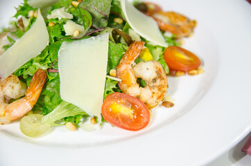 salad with shrimps on a white plate close up